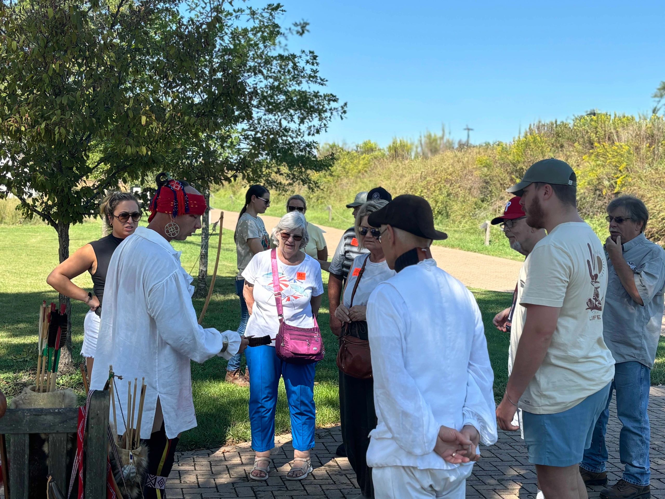 A group of people gathered outdoors, listening to a guide.